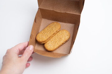 Cookies, handmade cakes, homemade baked goods in craft packaging. A girl's hand takes cookies out of the packaging. Sweet food, snack.