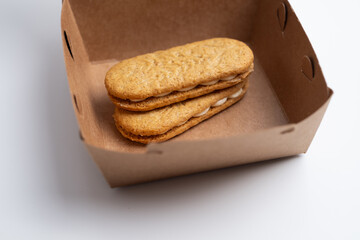 Cookies, handmade cakes, homemade baked goods in craft packaging. A girl's hand takes cookies out of the packaging. Sweet food, snack.
