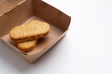 Cookies, handmade cakes, homemade baked goods in craft packaging. A girl's hand takes cookies out of the packaging. Sweet food, snack.
