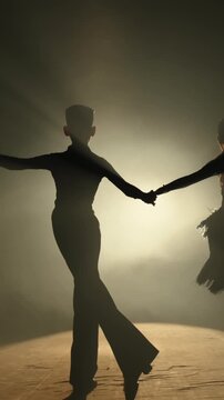 Teen Couple Performing Expressive Dance On Stage In Warm Light