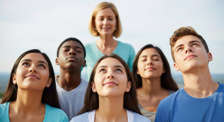 Inspiring portrait of a multiethnic group of students with their teacher, looking up together with faith and aspiration for a bright future