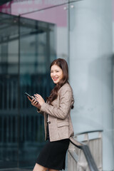 Fototapeta premium Smiling Businesswoman Using Mobile Phone Outdoors