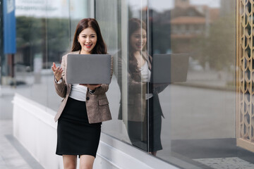 Smiling Businesswoman Holding Laptop Outdoors