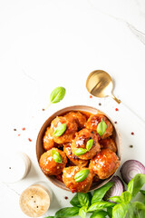 Meatballs in tomato sauce on white background.
