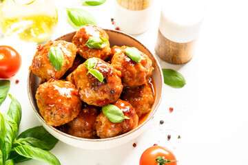Glazed Meatballs in tomato sauce on white table.