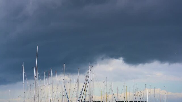 Dark storm clouds over marina sailboat masts