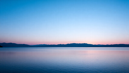 Obraz premium Serene lake at dusk with mountains