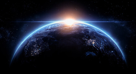 Obraz premium A blue, glowing earth with the sun rising on it, against a dark background.