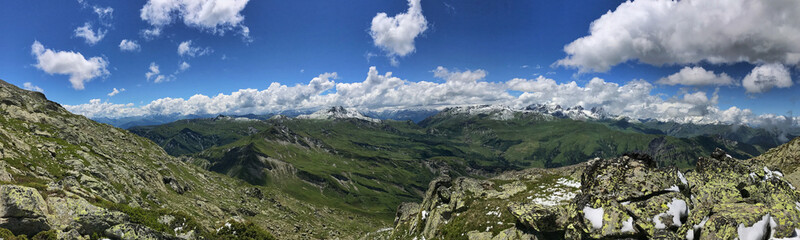 Fototapeta premium Majestic mountain panorama with lush green landscapes and dramatic cloudy skies