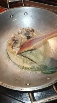 Flipping Daing na Isda While Frying
