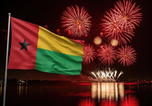 guinea-bissau flag waving against vibrant fireworks display over calm waterfront. celebration of pride, independence day. event poster, national banner, and festive decoration