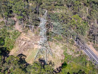 Drone aerial photograph of an electrical transmission tower running through regional bushland in the Blue Mountains in NSW, Australia.