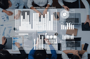 Group of professionals engaged in a marketing planning session, analyzing data charts and collaborating on strategies in a modern office for business growth. Axiom