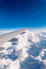Obraz premium View from the airplane window at a beautiful cloudy sky and the airplane wing
