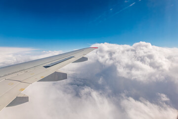 Obraz premium View from the airplane window at a beautiful cloudy sky and the airplane wing