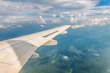 View from the airplane window at a beautiful cloudy sky and the airplane wing