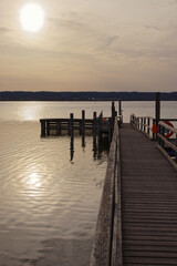 Obraz premium Old landing pier behind reeds on a lake with backlight