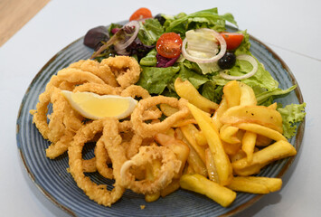 Fried squid rings with french fries and salad