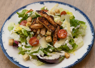 Caesar salad with grilled chicken and cherry tomatoes, close-up