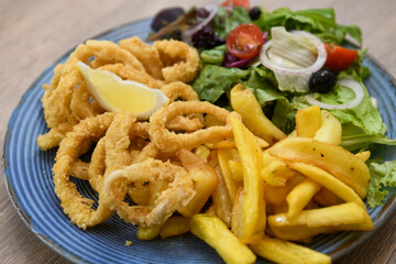Fried squid rings with french fries and salad