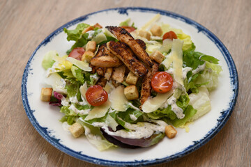 Caesar salad with grilled chicken and cherry tomatoes, close-up