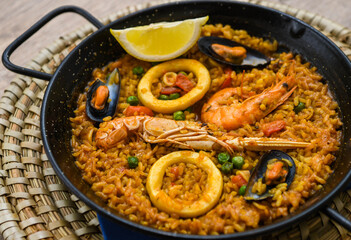 Spanish paella with seafood on a wooden table. Traditional spanish dish