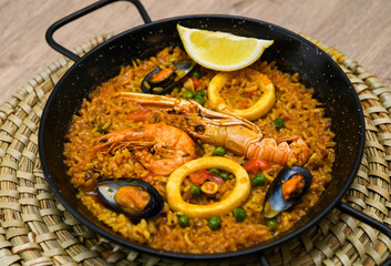 Spanish paella with seafood on a wooden table. Traditional spanish dish