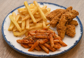 crispy fried chicken strips, French fries, and penne pasta with tomato sauce