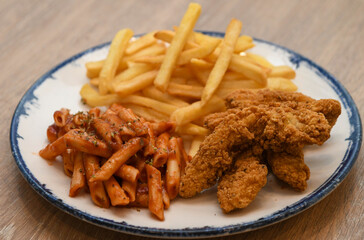 crispy fried chicken strips, French fries, and penne pasta with tomato sauce