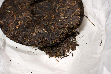 Compressed cake of puer tea showcases its dark leaves and texture.