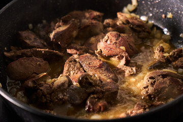 Cooking liver in a frying pan with herbs and spices for a savory dish