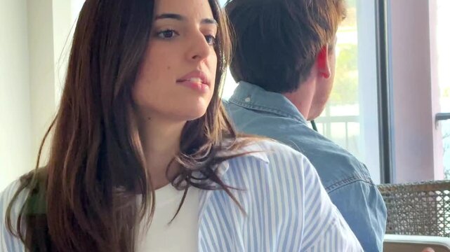 Serious couple sitting on sofa at home talking and confronting each other, thoughtful and sad mood as if during relationship therapy or difficult conversation, concept of communication, crisis and emo