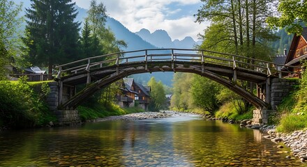 Fototapeta premium Charming Wooden Bridge Arching Over a Serene River in a Lush Mountain Valley.