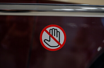 Obraz premium Warning sign featuring a hand symbol crossed out, indicating restricted access or no entry. Placed on a horizontal metal bar, the sign symbolizes caution and restriction. 