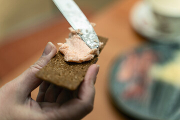 Spreading caviar and butter mixture on rye crispbread with table knife, perfect for culinary blogs and gourmet food content