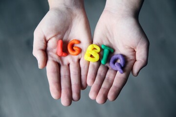 Letras LGBTQ de colores en las manos