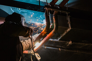 Metal soldering by welding method. A man using a welding machine solders metal in production. 