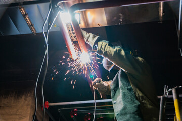 Metal soldering by welding method. A man using a welding machine solders metal in production. 