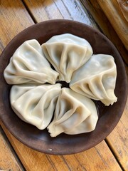 Traditional Georgian dumplings, khinkali on a ceramic plate on a wooden table