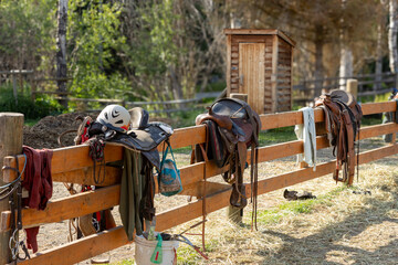 Horse saddles hanging on a fence at a ranch