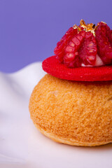 Macro of dessert with raspberry and gold - luxury, texture and bold colors on purple