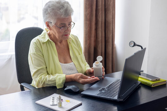 Elderly woman using laptop for telemedicine consultation, taking vitamins and supplements for healthy aging, heart and brain health, Alzheimer prevention, biohacking, longevity, senior healthcare