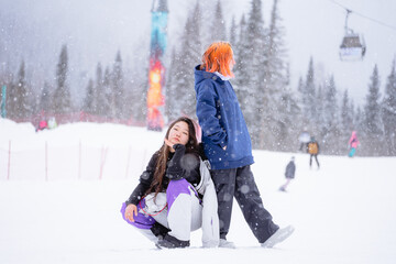 Happy modern girls, two positive girls of binary appearance against the backdrop of a winter landscape