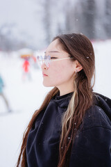 Asian-looking woman in profile with long brown hair, portrait in winter