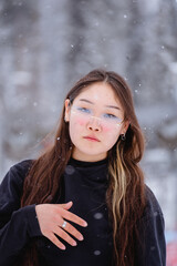 An Asian woman with long brown hair and heart-shaped glasses, portrait in winter