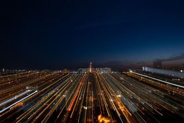 Night cityscape with dynamic zoom burst effect. Radiating light streaks from buildings and streets create a futuristic, energetic atmosphere against a twilight sky