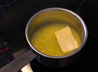 Melting butter in a saucepan. Cooking food on stove.