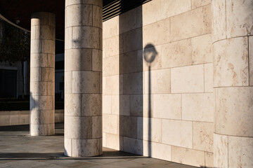 Shadows from low sun on modern building facade and exterior and columns