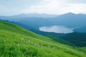 Rolling Hills and Serene Lake: A breathtaking panorama unfolds, showcasing vibrant green hills cascading down to a tranquil lake, all under a vast sky that paints a serene and picturesque scene.