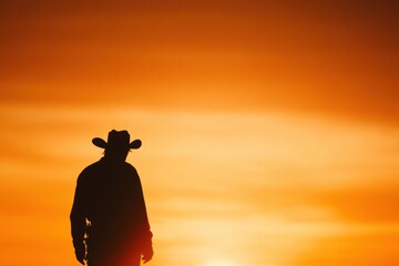 Sunset Silhouette of a Cowboy: A lone cowboy stands in silhouette against a vibrant sunset, embodying the spirit of the American West and evoking feelings of solitude and strength.